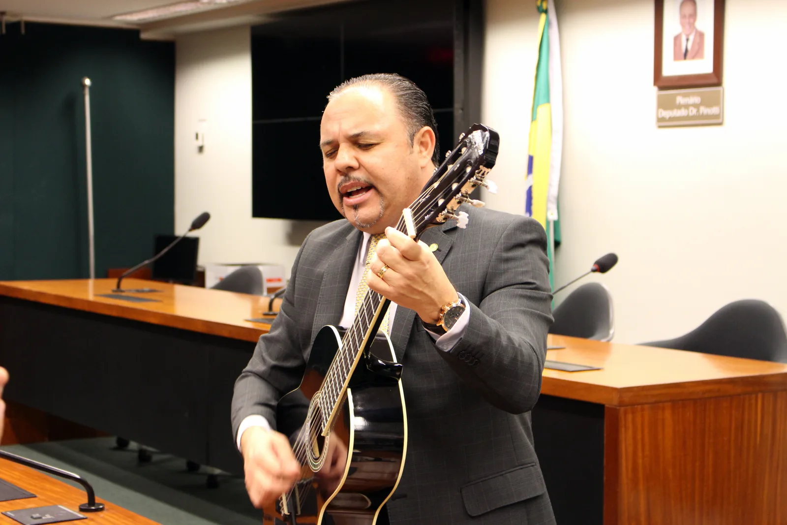 Flavinho tocando violão durante atividade de seu ministério